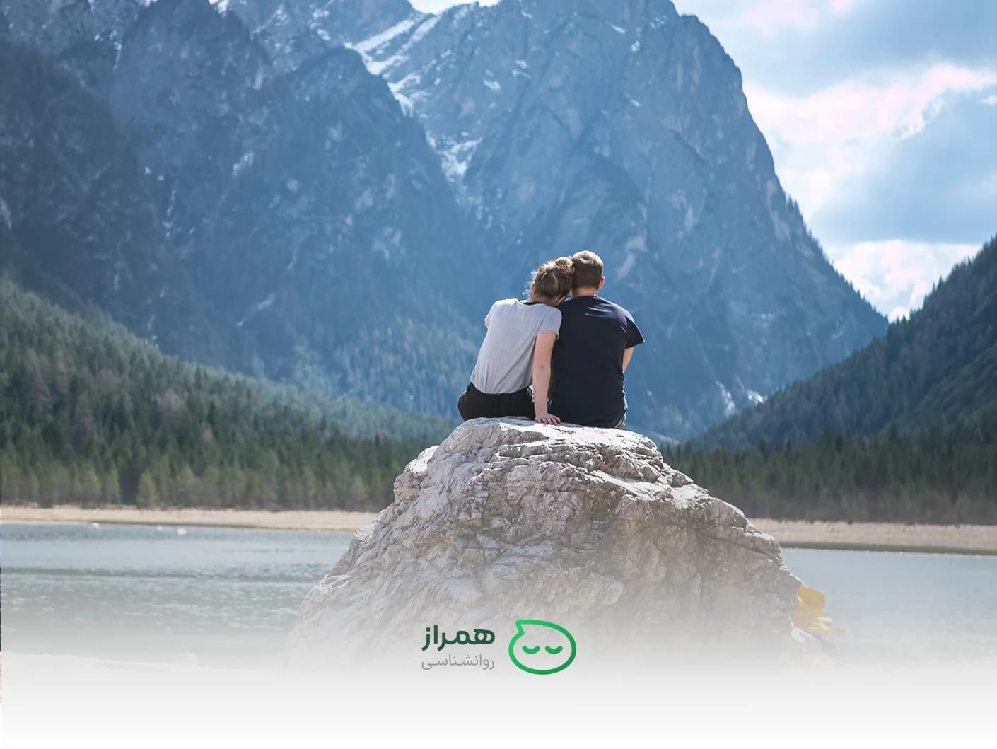 Couple sitting on a rock, looking at the mountains – emotional connection and relationship harmony – Hamraz Psychology