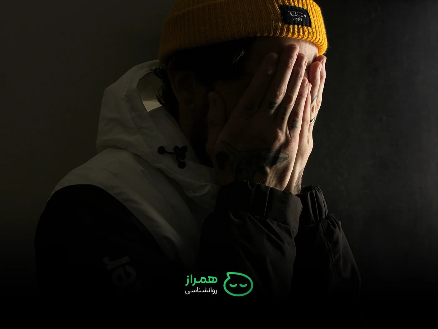 A person concealing their face, visually conveying feelings of helplessness, stress, and emotional burden